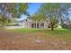 The backyard features ample green space, a balcony, and mature trees providing shade at 227 Blue Crystal Dr, Deland, FL 32720