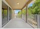 Outdoor balcony with a white metal railing and views of lush green trees and neighboring buildings at 227 Blue Crystal Dr, Deland, FL 32720
