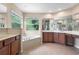 Bright bathroom features a soaking tub, tiled floors, a vanity with dual sinks, and large windows at 227 Blue Crystal Dr, Deland, FL 32720