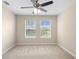 Well-lit bedroom featuring neutral walls, carpet flooring, and two windows with views of the surrounding landscape at 227 Blue Crystal Dr, Deland, FL 32720