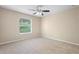 Cozy bedroom with neutral carpet, ceiling fan, and a window providing natural light at 227 Blue Crystal Dr, Deland, FL 32720
