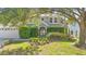 Two-story home featuring a manicured lawn and lush landscaping, surrounded by mature trees at 227 Blue Crystal Dr, Deland, FL 32720