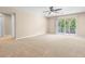Bright living room featuring neutral walls, carpet flooring, a ceiling fan, and sliding glass doors to the balcony at 227 Blue Crystal Dr, Deland, FL 32720