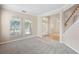 Inviting living room with carpet, bright windows, staircase and view into other living spaces at 227 Blue Crystal Dr, Deland, FL 32720