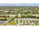 An aerial view of a neighborhood with tree-lined streets, a pond, and well-maintained homes at 241 Old Moss Cir, Deland, FL 32724
