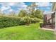 Lush backyard with manicured lawn, mature trees, and access to the screened patio at 241 Old Moss Cir, Deland, FL 32724