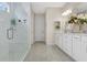 Bathroom featuring double sinks, a large mirror, white cabinetry and a glassed shower at 241 Old Moss Cir, Deland, FL 32724
