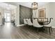Stylish dining room with gray accent wall, pendant lighting, hardwood floors and seating for six at 241 Old Moss Cir, Deland, FL 32724