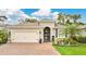Charming home featuring a lush lawn, brick driveway, attached garage, and well-maintained landscaping at 241 Old Moss Cir, Deland, FL 32724