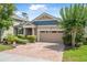 Attractive single-Gathering home with a two-car garage, brick driveway, and neatly landscaped front yard at 2412 Regency Park Dr, Deland, FL 32724