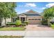 Charming single-story home boasts a two-car garage, brick driveway, and beautifully manicured front yard at 2412 Regency Park Dr, Deland, FL 32724