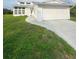 Charming home with a large two car garage and lush front yard with a curved sidewalk leading to the front door at 2689 Courtland Blvd, Deltona, FL 32738