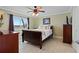 Comfortable bedroom with dark wood furniture, neutral decor, ceiling fan and serene water view at 2711 N Halifax Ave # 264, Daytona Beach, FL 32118