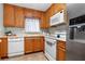 Cozy kitchen featuring white appliances, wood cabinets, and lots of counter space at 2711 N Halifax Ave # 264, Daytona Beach, FL 32118