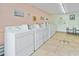 Well-maintained laundry room with multiple machines, seating, and decorative wall art at 2711 N Halifax Ave # 264, Daytona Beach, FL 32118