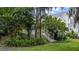 Backyard view with lush tropical landscaping, a small deck, and access steps, offering a private outdoor space at 275 Bayou Cir, Debary, FL 32713