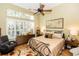 Bright bedroom featuring a ceiling fan, dresser and decorative pillows on the iron framed queen bed at 275 Bayou Cir, Debary, FL 32713