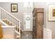 Light-filled foyer with wooden staircase, beautiful cabinet and decorative accents at 275 Bayou Cir, Debary, FL 32713
