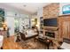 Cozy living room with fireplace and hardwood floors with natural lighting and views of the deck at 275 Bayou Cir, Debary, FL 32713