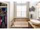 Stylish bathroom with tiled tub and jacuzzi jets and a fully stocked walk-in closet at 275 Bayou Cir, Debary, FL 32713
