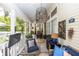 Relax on this spacious lanai featuring a wicker sofa, glass table, ceiling fan, and tropical plants at 275 Bayou Cir, Debary, FL 32713
