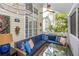 Relax on this spacious lanai featuring a wicker sofa, glass table, ceiling fan, and tropical plants at 275 Bayou Cir, Debary, FL 32713