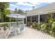 An outdoor patio with a table, umbrella, chairs, and a view of lush greenery, perfect for relaxing at 275 Bayou Cir, Debary, FL 32713
