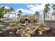 Close-up of an attractive rock water feature with a small waterfall, surrounded by landscaping and a white railing at 275 Bayou Cir, Debary, FL 32713