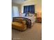 Bedroom features a decorative wood bed frame, bench, patterned carpet, and ample natural light from the window at 2898 Ocean Shore Blvd # 603, Ormond Beach, FL 32176