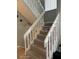 Carpeted staircase with white railing leads to the upper level of the house, providing an easy transition between floors at 2898 Ocean Shore Blvd # 603, Ormond Beach, FL 32176