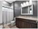 Elegant bathroom featuring a granite countertop, a tub with a shower, and a stylish mirror at 2948 Bella Flore Ter, New Smyrna Beach, FL 32168