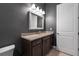 A vanity with stone countertops in the bathroom are complimented with a framed mirror and modern fixtures at 2948 Bella Flore Ter, New Smyrna Beach, FL 32168