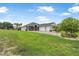 Beautiful exterior view of home with a lush green lawn, brick driveway, and an attached three car garage at 2948 Bella Flore Ter, New Smyrna Beach, FL 32168