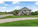 Home's manicured lawn is accented by vibrant plants, a palm tree, and a brick driveway at 2948 Bella Flore Ter, New Smyrna Beach, FL 32168