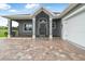 Home's inviting front entrance features an elegant door, stylish brickwork, and an attached two car garage at 2948 Bella Flore Ter, New Smyrna Beach, FL 32168