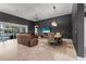 Open-concept living and dining area with hardwood floors, dark walls, and sliding glass doors to the pool at 2948 Bella Flore Ter, New Smyrna Beach, FL 32168