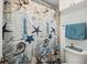 Nautical themed bathroom featuring seashell patterned shower curtain and complementary blue towel at 2987 S Atlantic Ave # 901, Daytona Beach, FL 32118