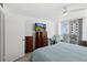 Bedroom with balcony access, featuring a TV and a comfortable armchair at 2987 S Atlantic Ave # 901, Daytona Beach, FL 32118