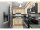 Functional kitchen with stainless steel appliances, light wood cabinets, and green countertops at 2987 S Atlantic Ave # 901, Daytona Beach, FL 32118