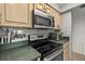 Kitchen featuring stainless steel appliances, updated microwave, and sleek black electric stove at 2987 S Atlantic Ave # 901, Daytona Beach, FL 32118