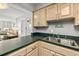 Kitchen featuring wood cabinets, stainless steel sink, and green countertops that open to the living room at 2987 S Atlantic Ave # 901, Daytona Beach, FL 32118
