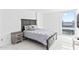 A primary bedroom featuring a large bed, a nightstand, and access to a window with a view at 3047 S Atlantic Ave # 1805, Daytona Beach, FL 32118