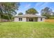 Large, newly sodded backyard, back of house with sliding glass doors, and privacy fence at 349 Baker Ave, Lake Helen, FL 32744