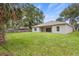 Large, newly sodded backyard, back of house with sliding glass doors, and privacy fence at 349 Baker Ave, Lake Helen, FL 32744