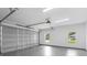 Garage interior showing a large metal door, bright lighting, and windows providing natural light at 349 Baker Ave, Lake Helen, FL 32744