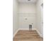 Bright laundry room featuring wood-look flooring, a utility sink, and a wire shelf for storage at 349 Baker Ave, Lake Helen, FL 32744