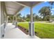 Covered front porch with decorative columns, green lawn, and landscaping at 349 Baker Ave, Lake Helen, FL 32744