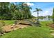 Picturesque backyard view featuring a charming stone bridge amidst lush landscaping and a serene pond at 3592 Grande Tuscany Way, New Smyrna Beach, FL 32168