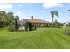 Expansive backyard with lush green lawn, mature landscaping, screened patio, and tiled roof at 3592 Grande Tuscany Way, New Smyrna Beach, FL 32168