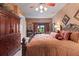 Comfortable bedroom features a large bed, wood furniture, and a ceiling fan at 3592 Grande Tuscany Way, New Smyrna Beach, FL 32168